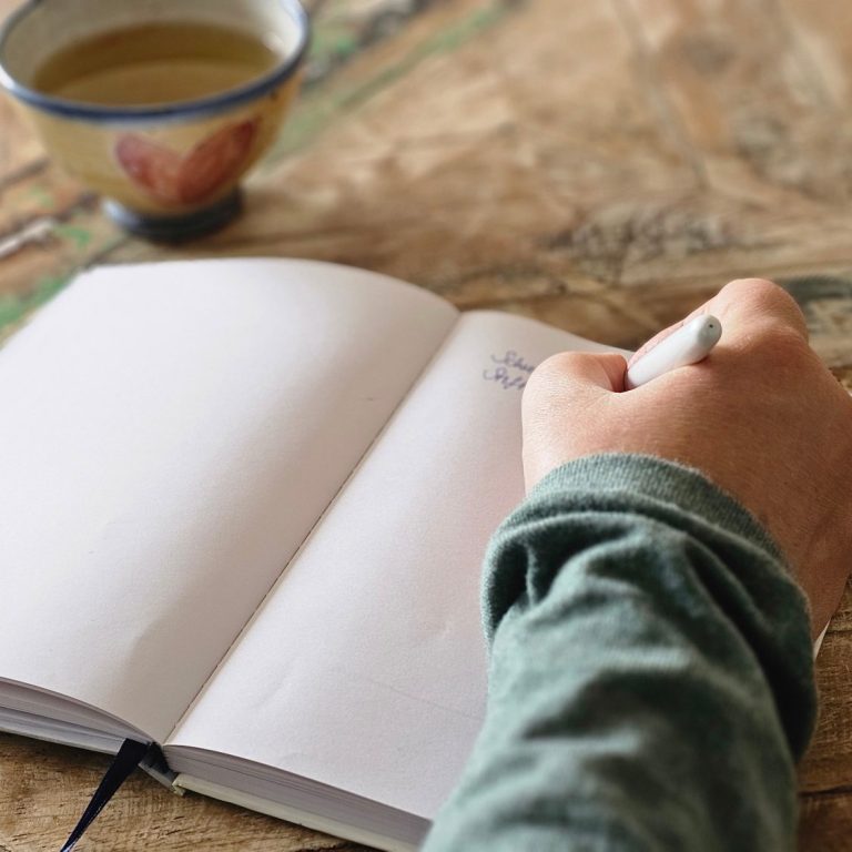 Intuitives Schreiben Eine Hand, die in ein Notizbuch schreibt.